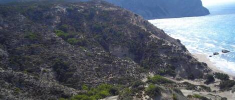 A rugged coastline with rocky terrain and sparse vegetation.