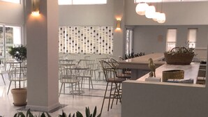 Un interior moderno con una isla central, zona de estar e iluminación decorativa.