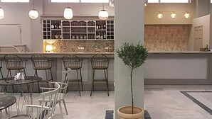 Una cocina moderna con taburetes de bar, una isla central e iluminación colgante.