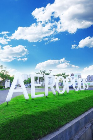 A large outdoor sign with the word "AEROPOLIS" in white letters on a grassy area.