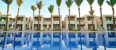 Un hotel con piscina, palmeras y arquitectura moderna.