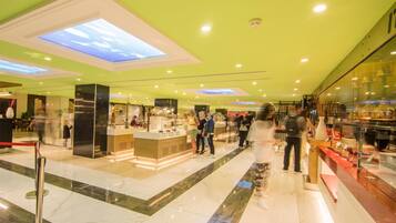 A modern interior with a central counter, glass display cases, and a green ceiling.