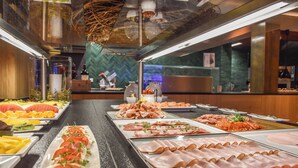 A buffet with various food options including fruits, vegetables, and meats.