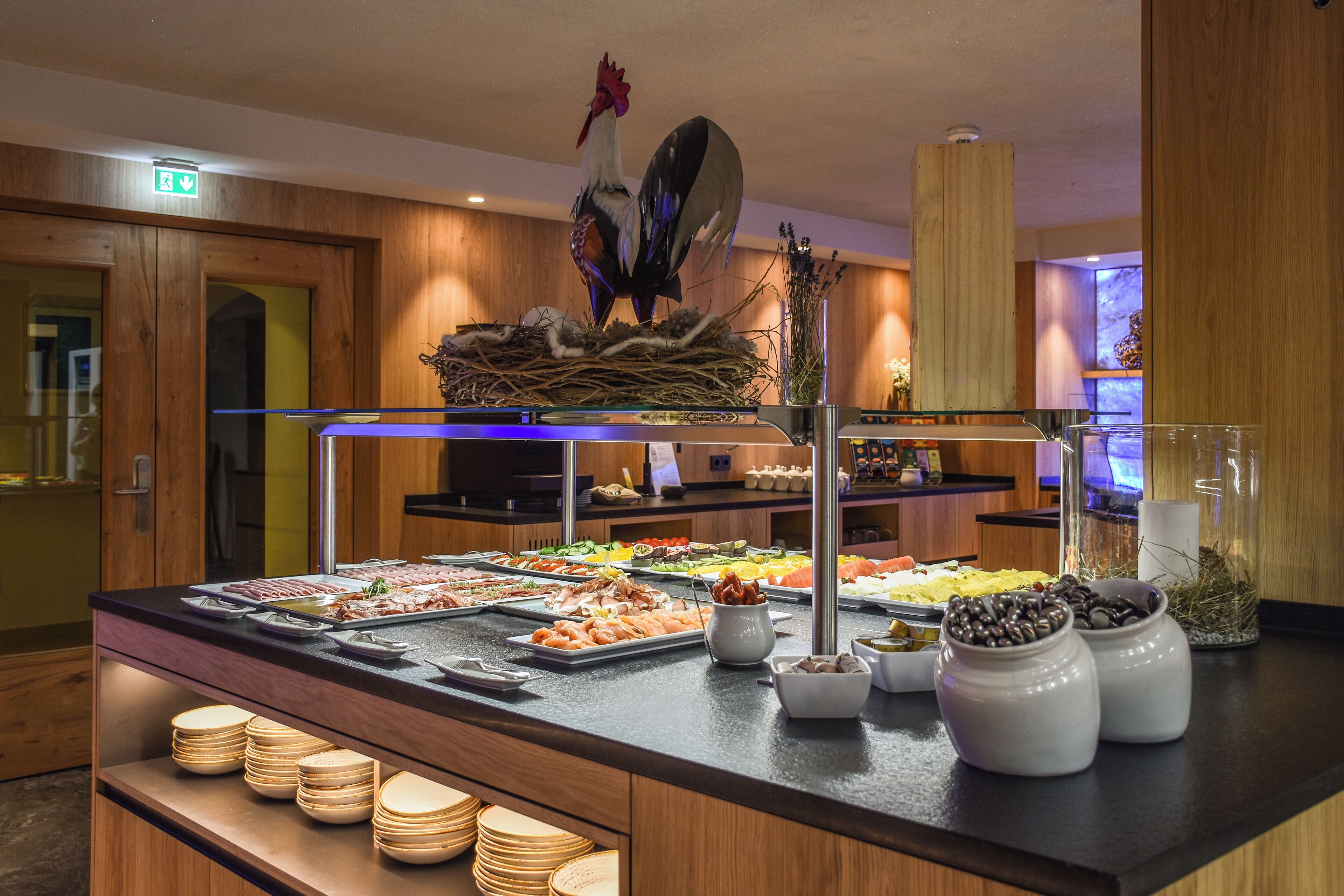 Ein reichhaltiges Buffet mit verschiedenen Speisen und einer dekorativen Hahnenfigur.