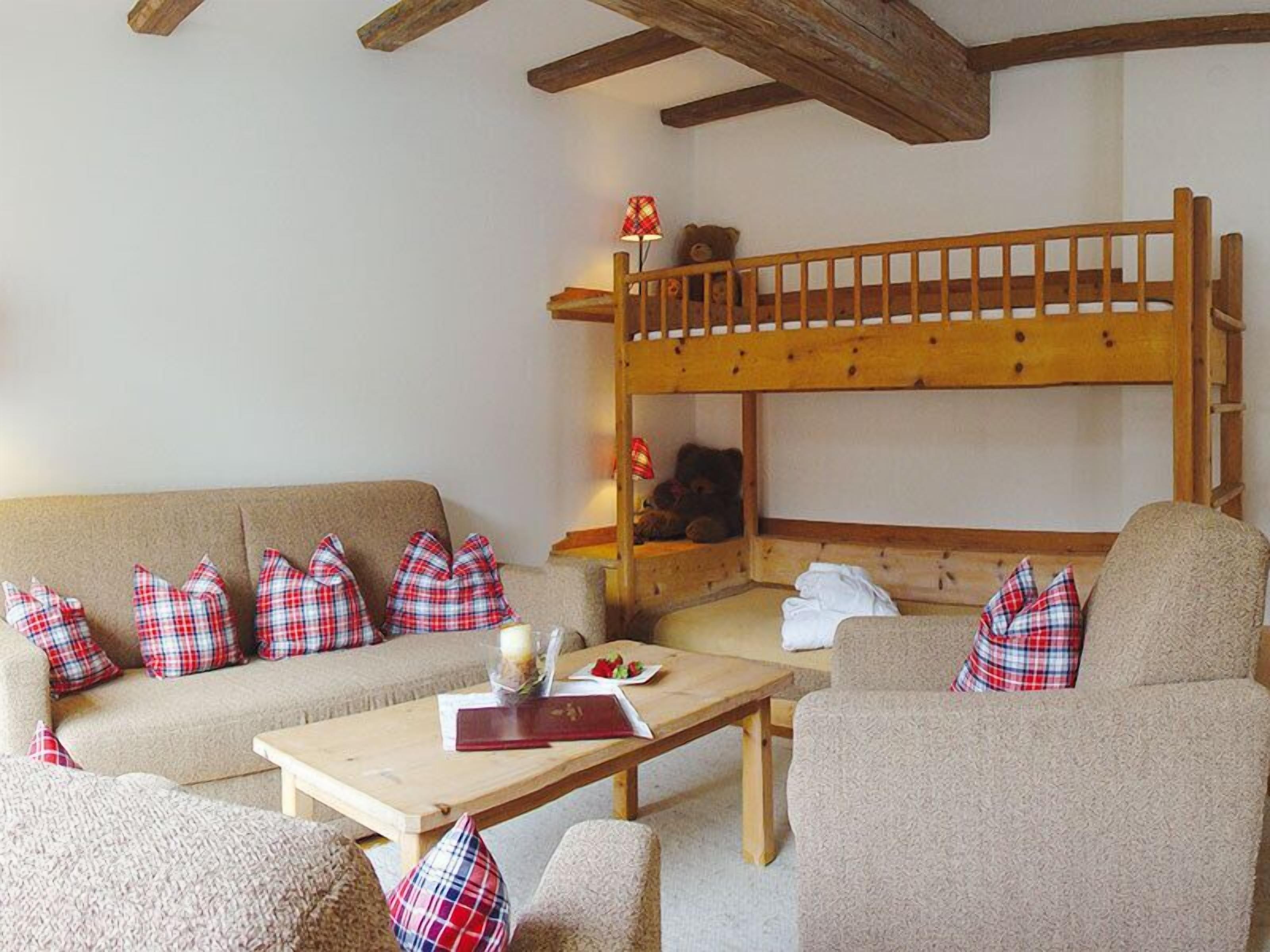 A cozy room with a bunk bed, a sofa, and a coffee table.