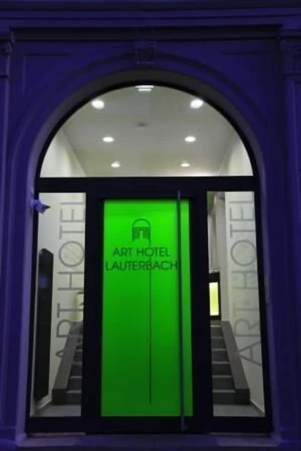 Entrada al ART HOTEL LAUTERBACH, con un letrero verde y una escalera que conduce al interior.