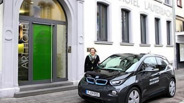 A black BMW parked in front of the ART HOTEL LAUTERBACH.