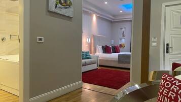 A modern bedroom with a large bed, a red rug, and a ceiling with blue lighting.
