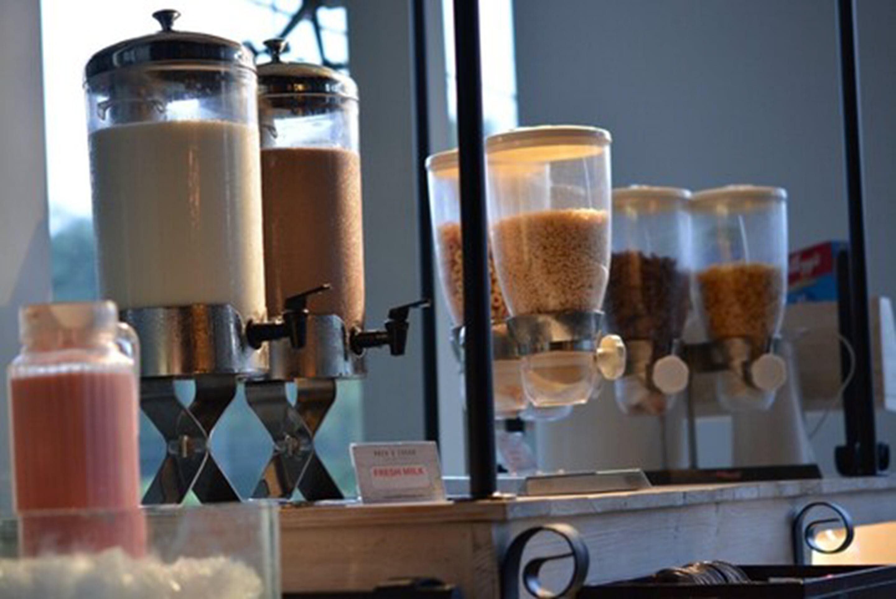 A coffee machine with milk dispensers and a fresh milk sign.