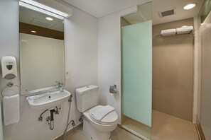 Une salle de bain moderne avec un lavabo, des toilettes et une douche à parois de verre.