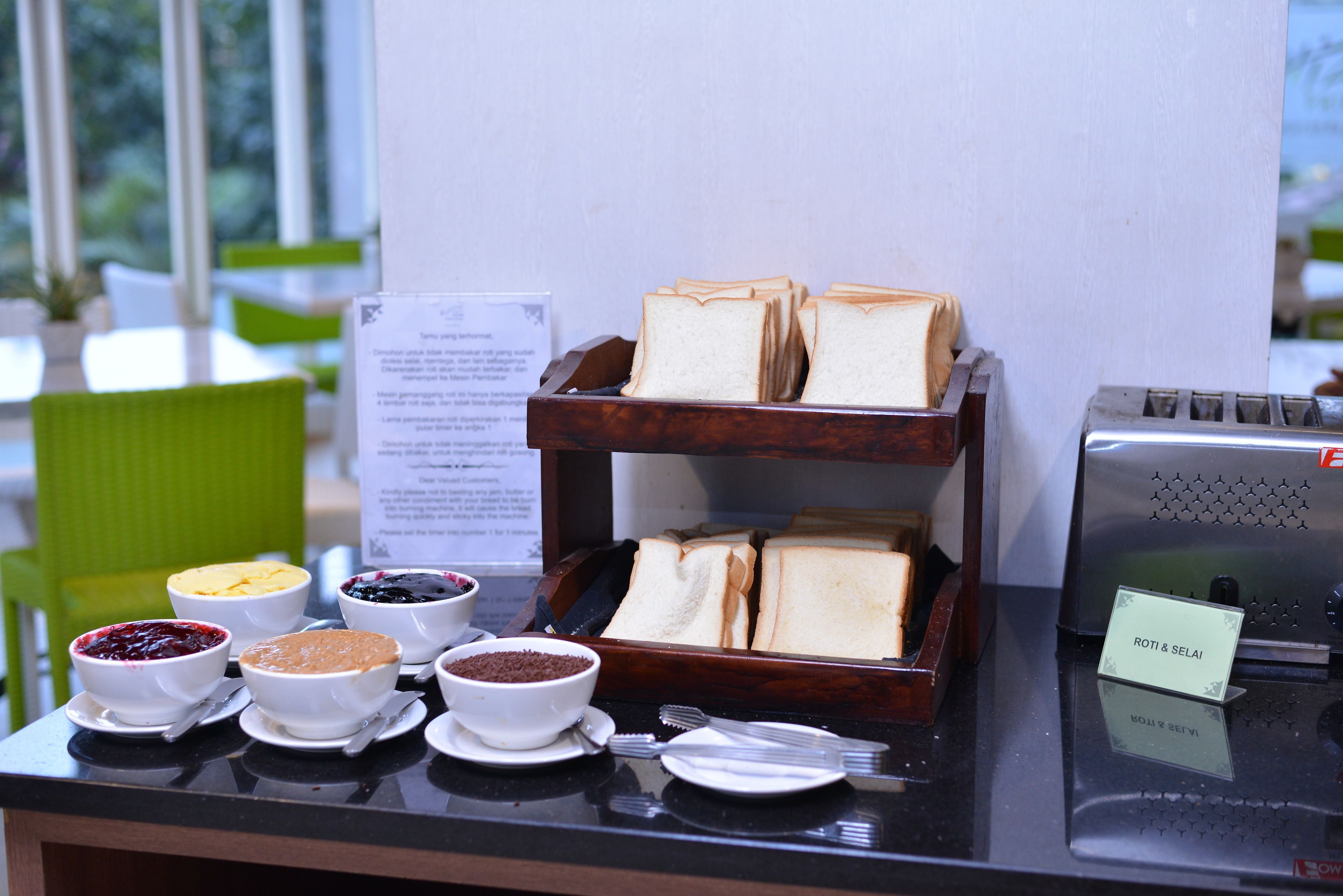 Un buffet de petit-déjeuner proposant une variété d’aliments, ainsi qu’un panneau indiquant le nom du restaurant.