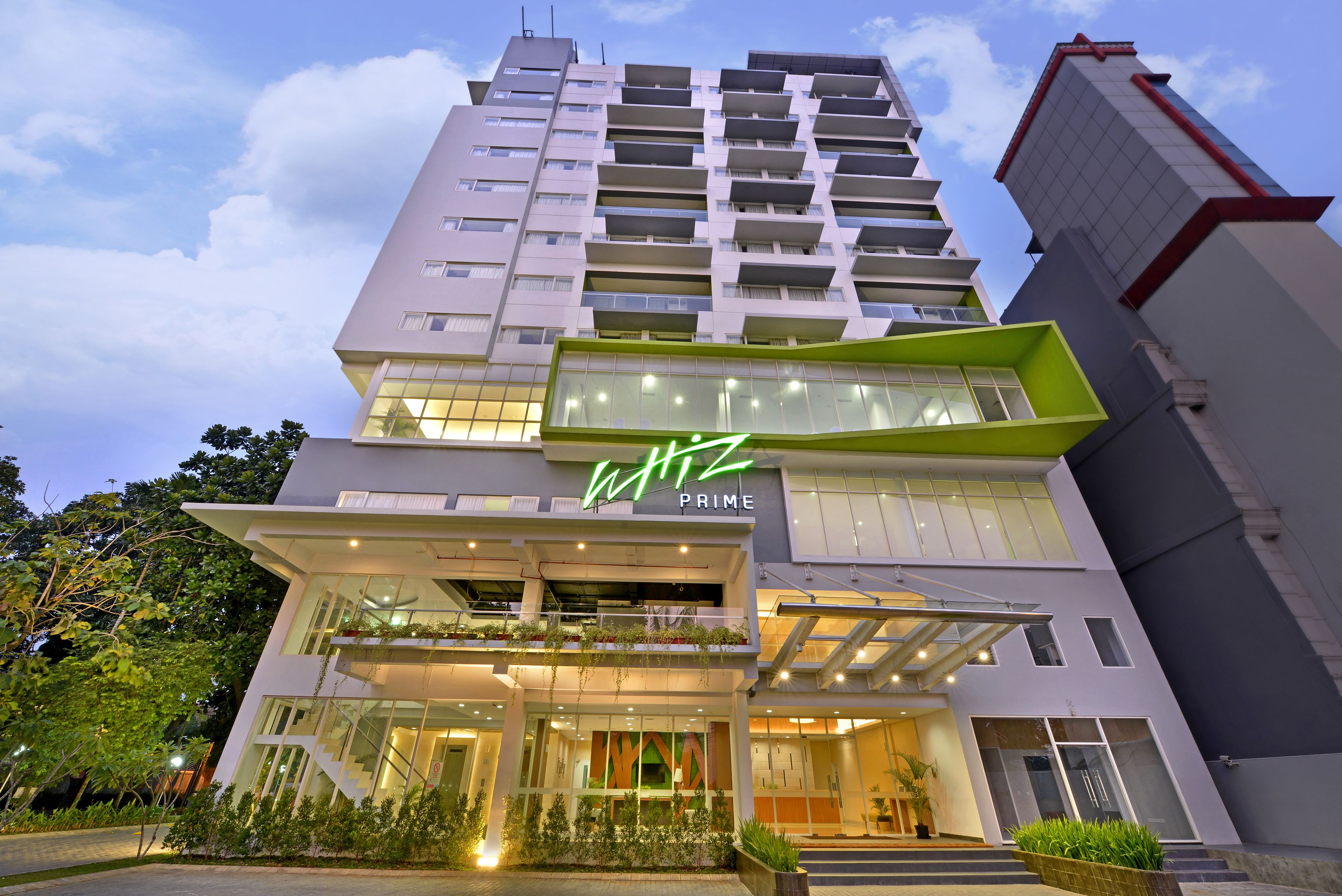 A modern hotel with a prominent 'Prime' sign, multiple balconies, and a well-lit entrance.