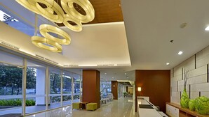 Eine moderne Hotelhalle mit Glasfassade, Holzboden und einer Rezeption.