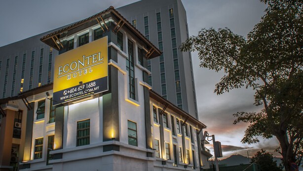 Edifício de hotel com uma placa de destaque exibindo o nome "ECONTEL HOTEL" e informações de contato.