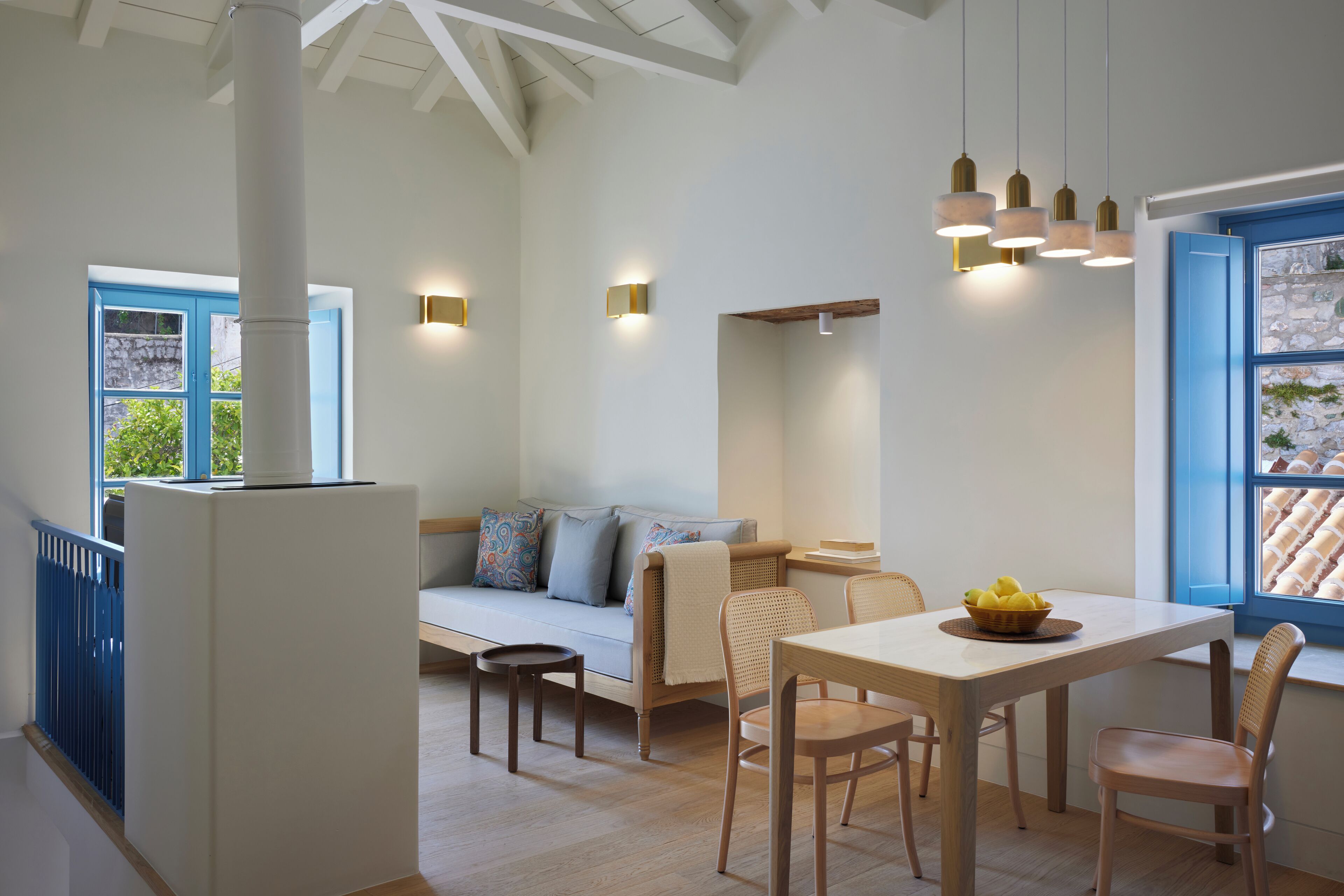 A modern interior with a dining area, a sofa, and a window with a view.