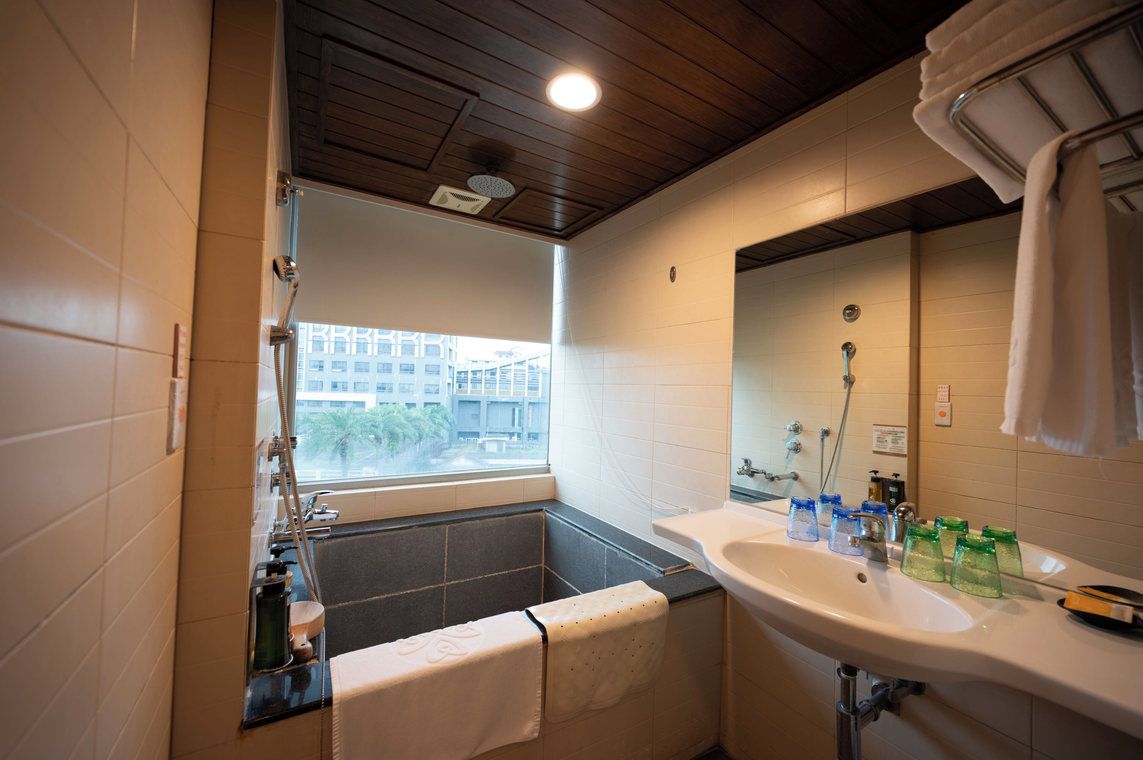 A bathroom with a bathtub, a sink, and a window.