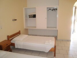 Un dormitorio con cama, mesita de noche, armario y espejo.