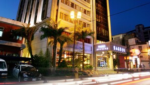 Un hotel de varios pisos con una entrada destacada y una señal visible.