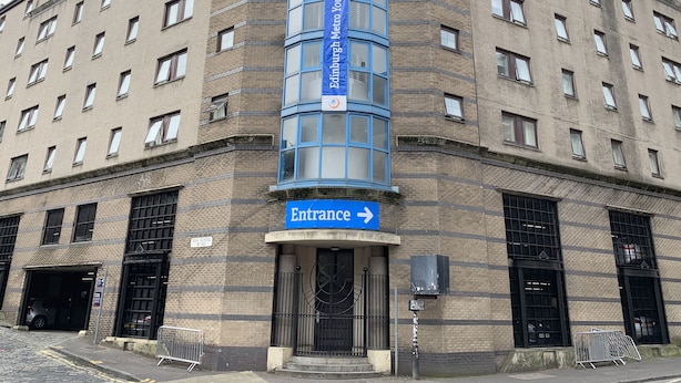 A corner building with a blue entrance sign, multiple windows, and a brick facade. - Edinburgh Metro Youth Hostel (Edinburgh)