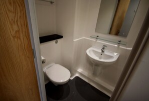 A bathroom with a toilet, a sink, and a mirror. - Edinburgh Metro Youth Hostel (Edinburgh)
