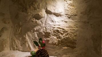 A dimly lit room with a textured wall, a pine cone, and a small Christmas decoration.