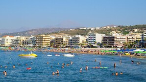 A coastal town with a beach, boats, and buildings along the shore. - AC Homes Christos (Rethymno)