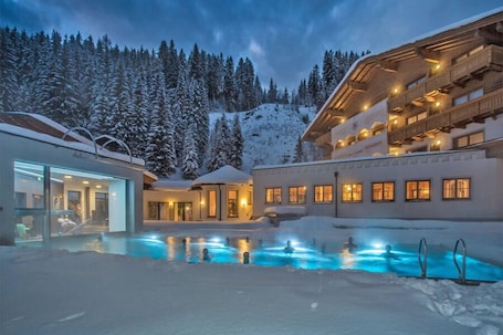 Indoor pool, outdoor pool, pool umbrellas, sun loungers. Landhotel Alpenhof