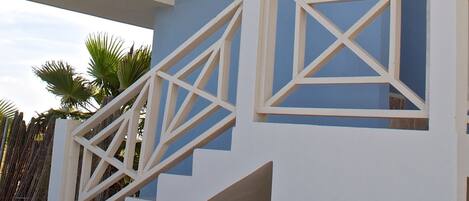 Un edificio de varios pisos con balcones blancos y paredes azules.