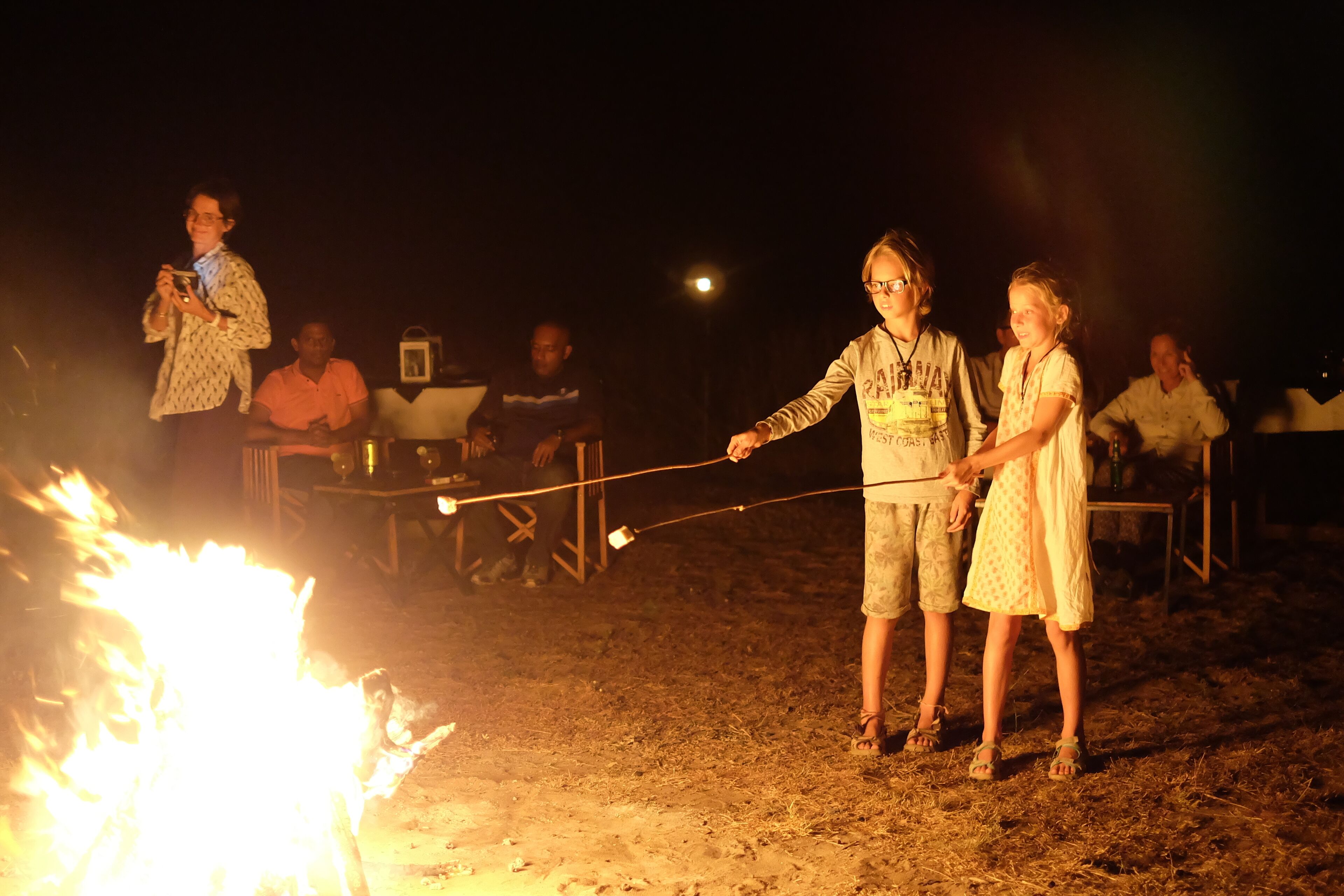A group of people gathered around a campfire at night.