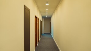 A narrow hallway with carpeted floors and wooden doors on one side. - Hotel Imperial (Quatro Barras)