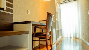 A dining area with a wooden table and chair, a staircase, and a view of a bright room through sheer curtains. - Hotel Imperial (Quatro Barras)