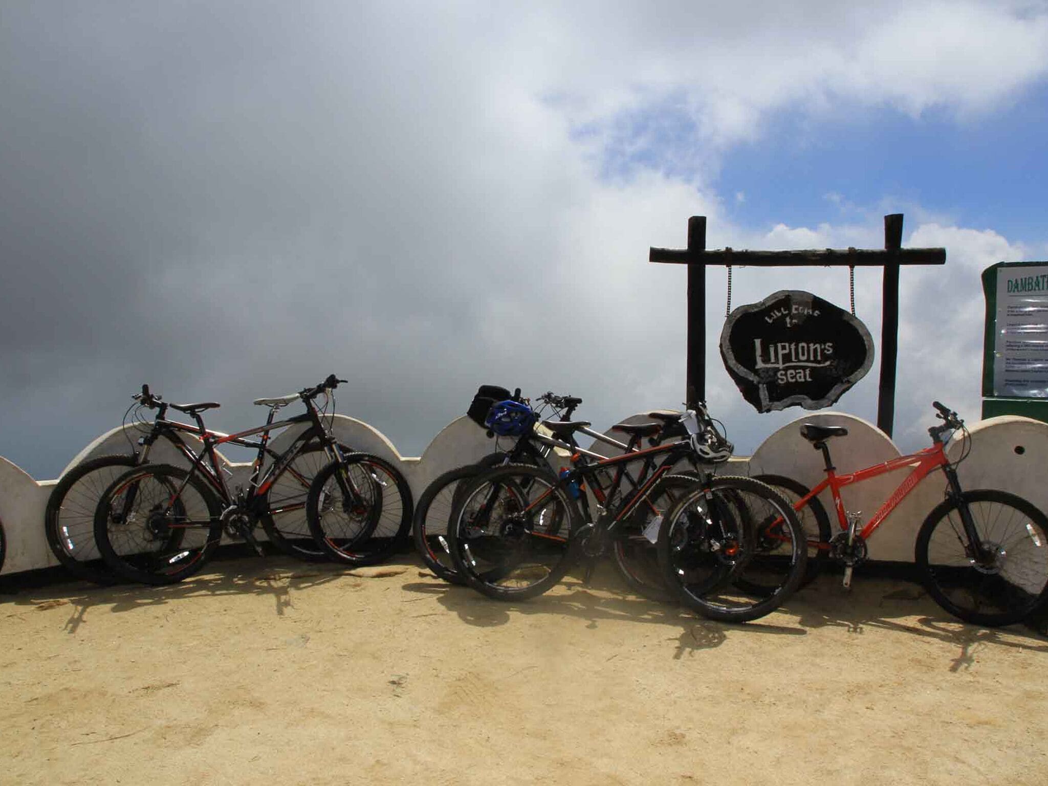 A row of bicycles parked against a wall with a sign that reads "Lupion's Seat."