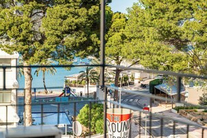 A view of a coastal area with a bar named "The Round Bar" visible through a fence.