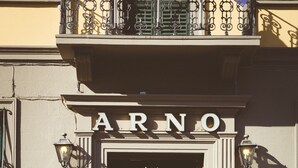 A vintage orange car parked in front of a building with a sign reading "ARNO". - Hotel Arno Bellariva  (Florence)