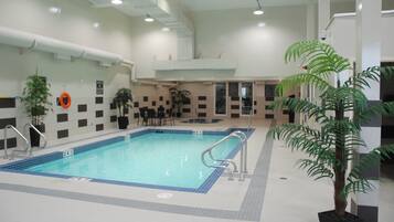 Una piscina techada, sillones reclinables de piscina