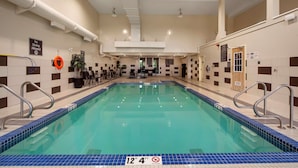 An indoor swimming pool with a no diving sign, a lifebuoy, and a pool depth sign.