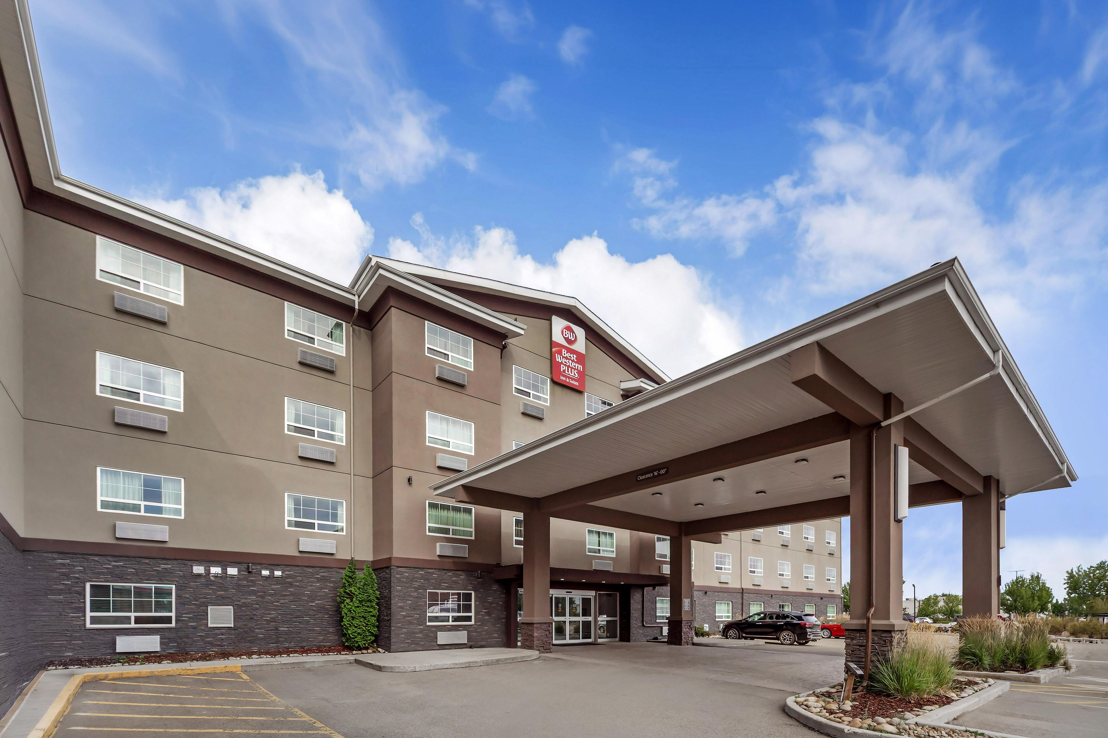 Un hotel con acceso cubierto, varias ventanas y estacionamiento.