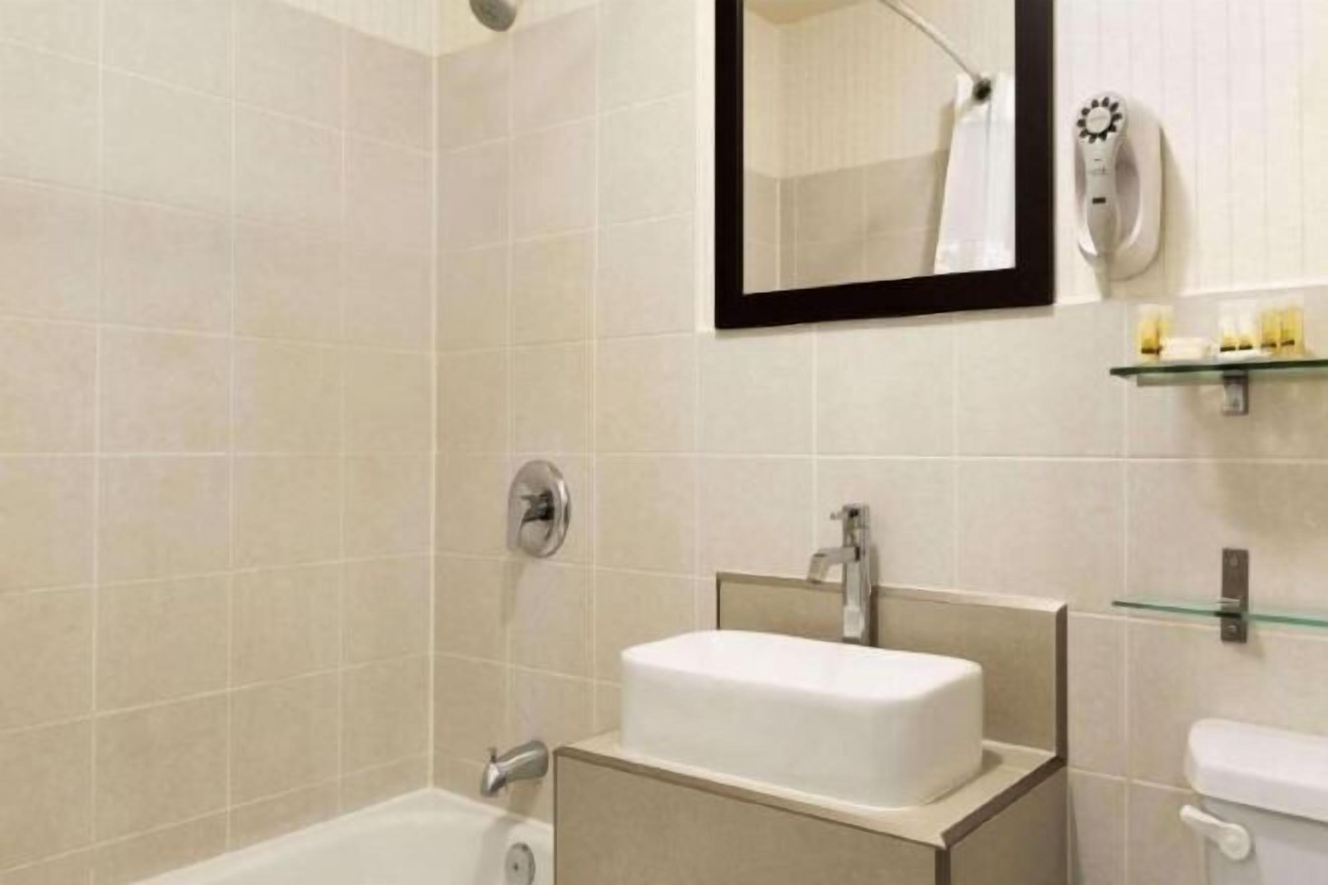 Badkamer | Een bad/douchecombinatie, gratis toiletartikelen, een haardroger