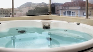 A hot tub with a view of buildings through a window. - Villa St Aubyn (São Vicente)