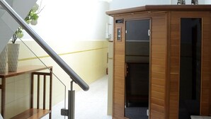 A modern interior with a wooden cabinet, a staircase, and a small table with a plant. - Villa St Aubyn (São Vicente)