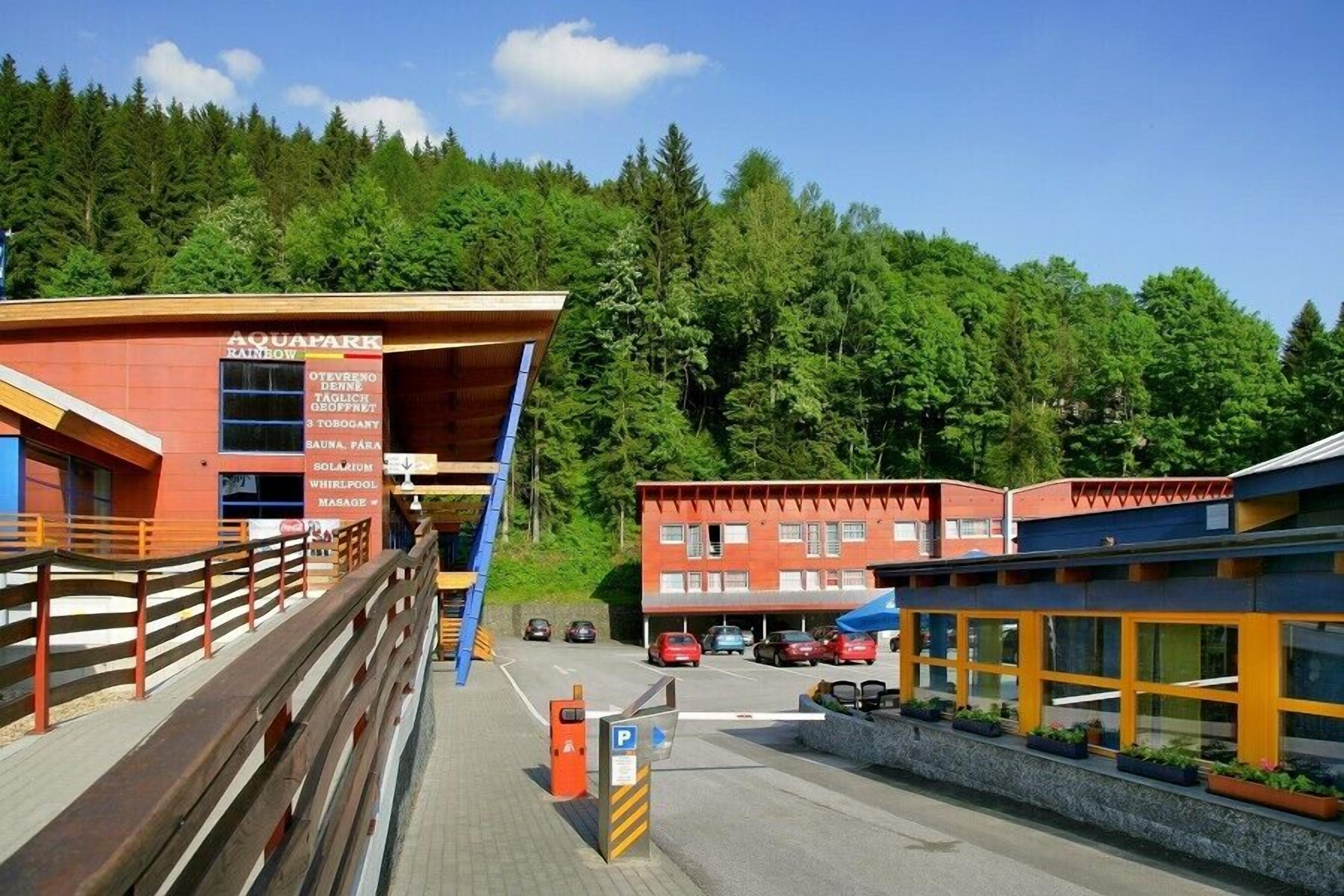 En byggnad med en skylt som visar texten ”AQUAPARK RAINBOW” och ”SAUNA PARA”.