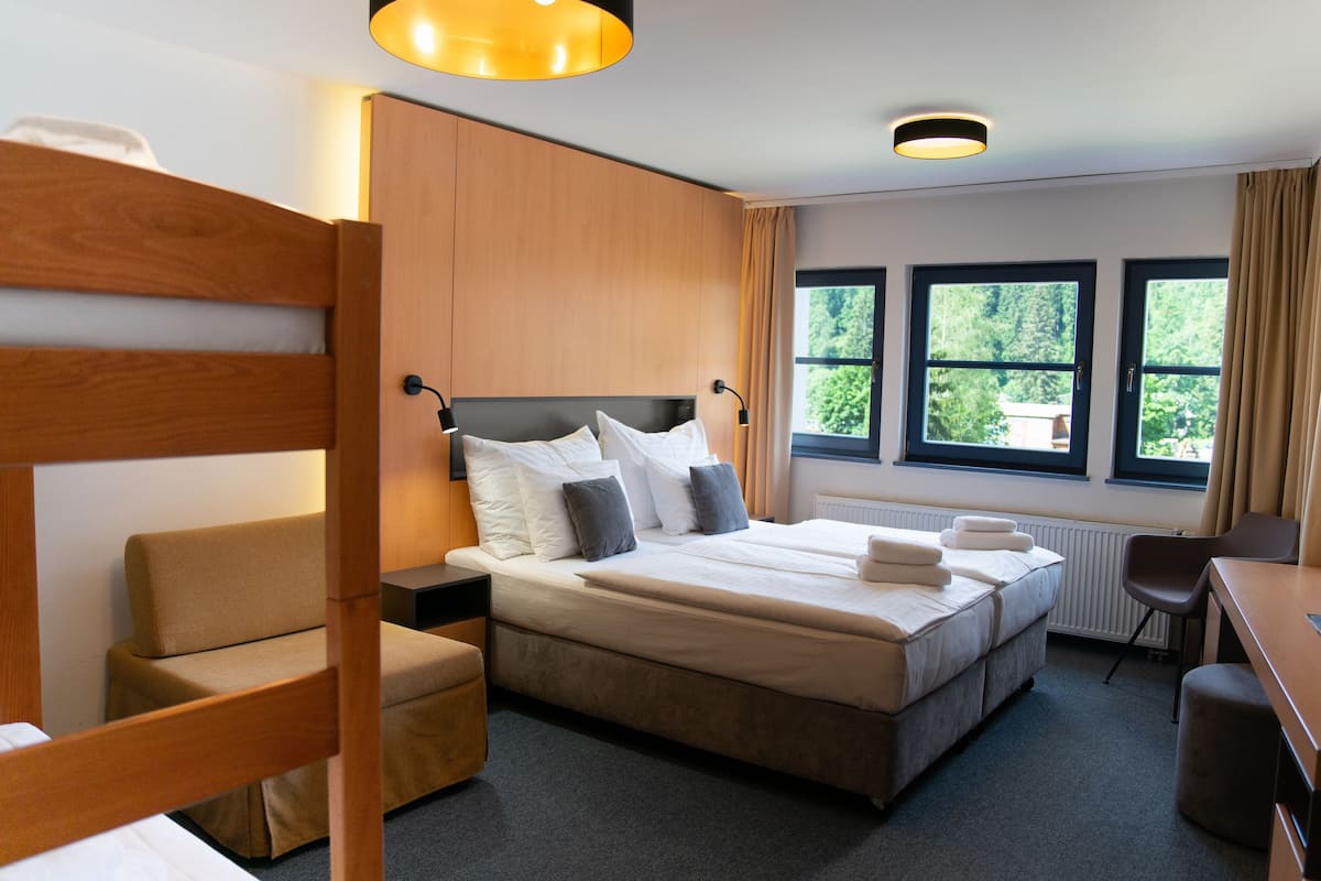 Ein Hotelzimmer mit einem Doppelbett, einem Holzkopfteil, einem Schreibtisch und einem Stuhl.