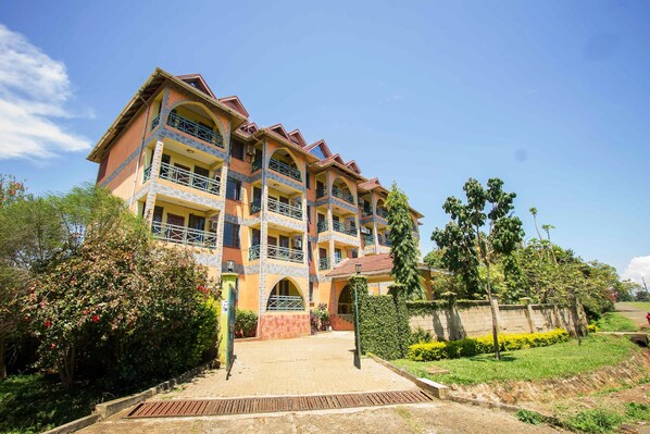 A multi-story hotel with balconies, a paved entrance, and surrounding greenery. - Parkview Safari Hotel and Apartments (Kisumu)