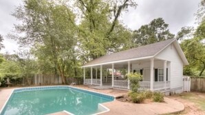A house with a covered porch, a swimming pool, and a fenced yard. - Huffman House (Minden)