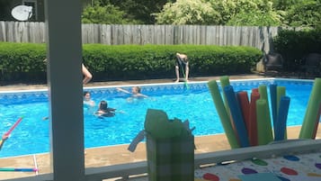 Una piscina al aire libre, sillones reclinables de piscina