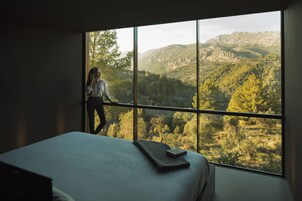 Una habitación con un gran ventanal que ofrece vistas a un paisaje montañoso.