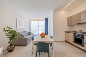 A modern apartment with a dining area, a kitchen, and a living room.