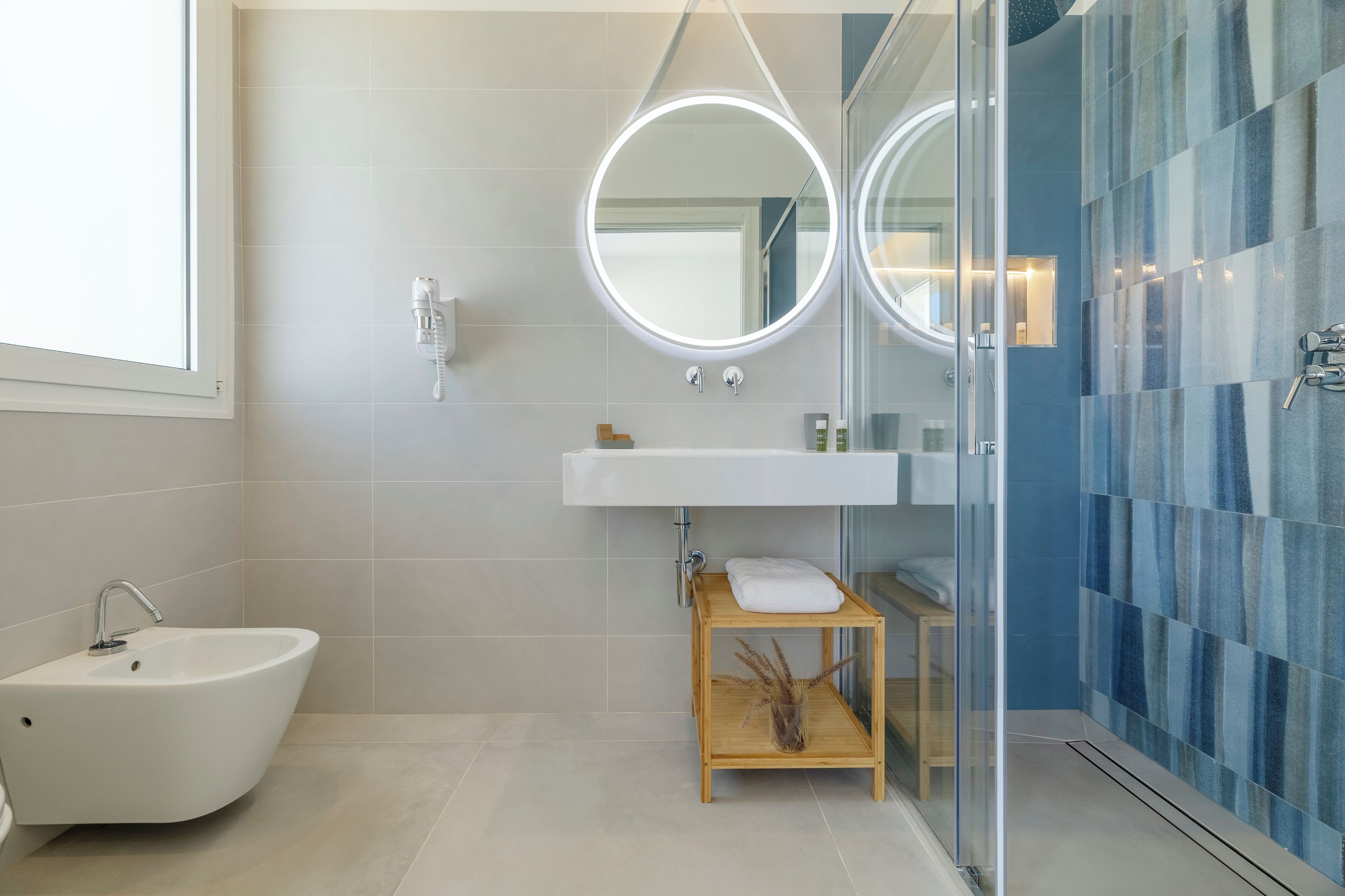 A modern bathroom with a freestanding bathtub, a sink with a mirror, and a glass shower enclosure.