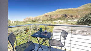 A balcony with a table set for two, a bottle of wine, and a small Christmas tree. - Case Vacanza Loria (San Vito Lo Capo)