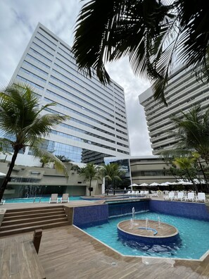 Alberca al aire libre y camastros 